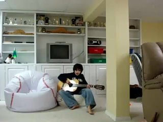 the boy plays the guitar barefoot